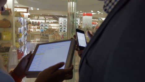 people with mobile and pad in hypermarket elevator