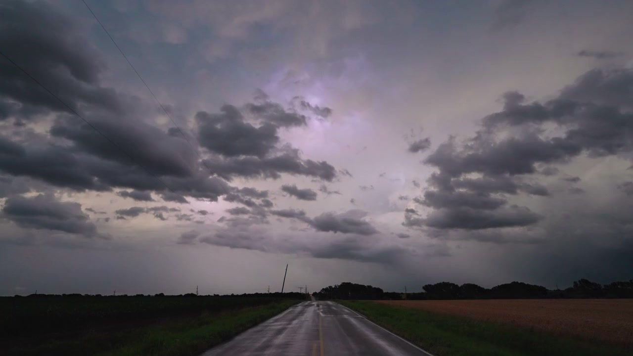 Una potente tempesta elettrica si muove nel cielo sopra una strada tranquilla, in una natura meravigliosa.