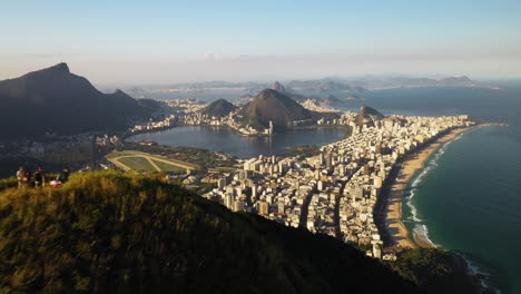 antena alrededor de excursionistas en la cima de la montaña que revela la ciudad de río de janeiro