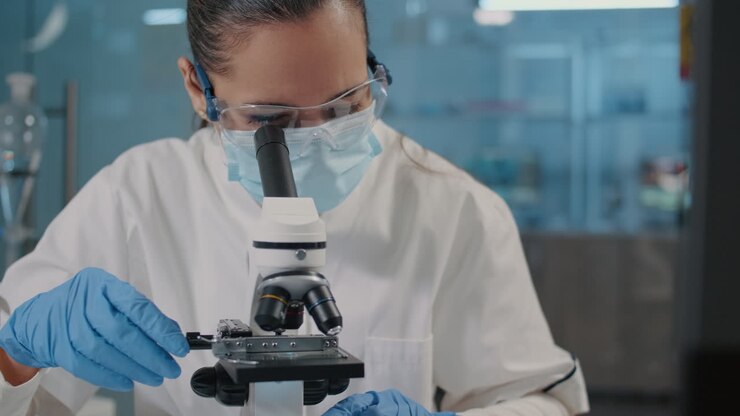Specialist working with microscope in science laboratory