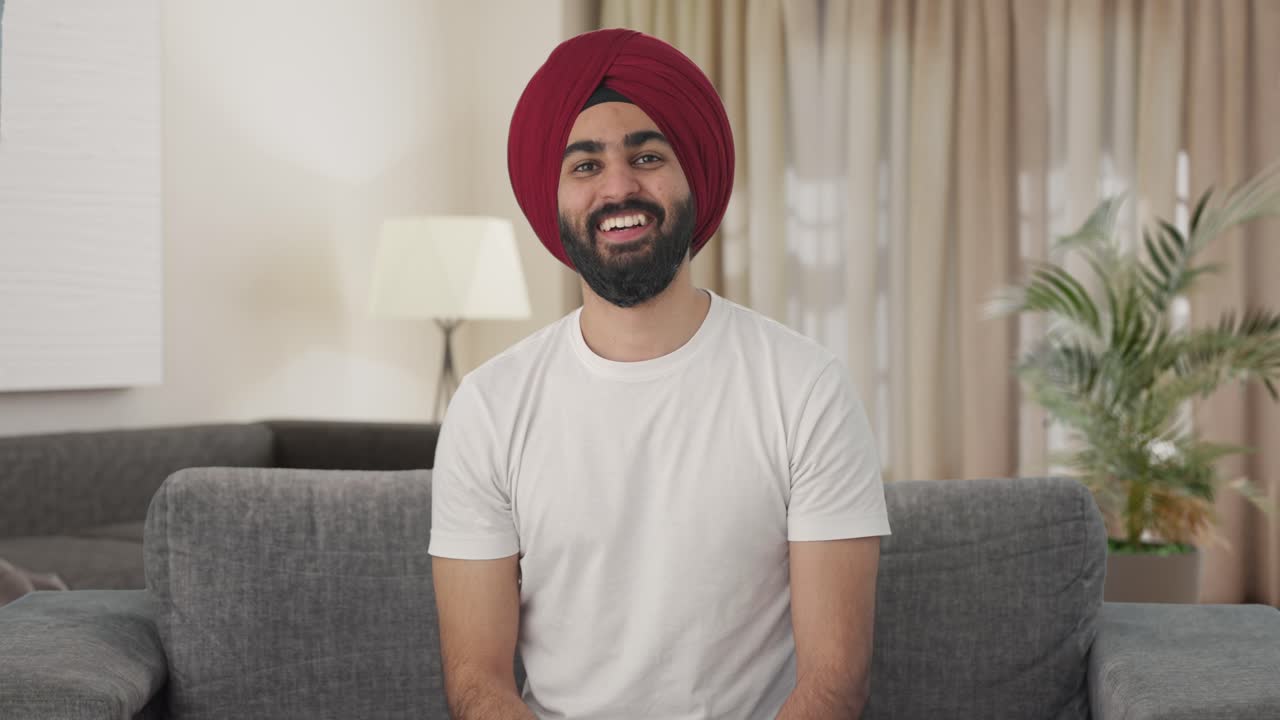 indio sikh hombre indio riendo mientras ve la televisión