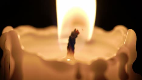 a close-up view highlights a candle flame flickering gently, illuminating its surroundings. the soft glow creates a peaceful atmosphere, perfect for relaxation and reflection.
