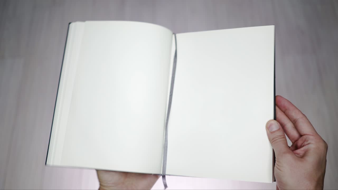 Man's hands opening  a blank book.