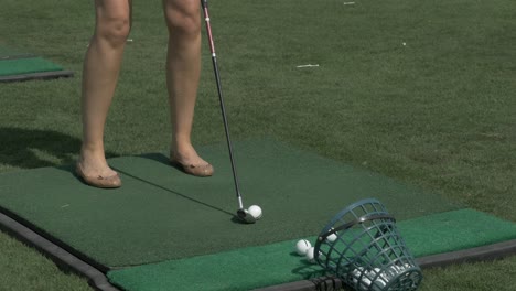 woman practicing golf swing at driving range