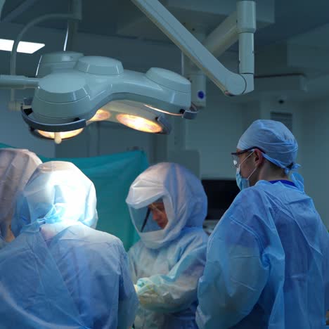 operation in surgical room. team of medical specialists in safety uniform perform a surgery under the bright lamp in the operating room.