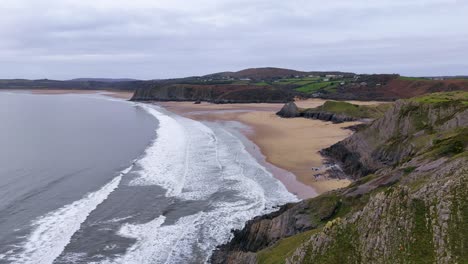 flying over the golden sandy coast of three cliffs bay gower peninsula in wales