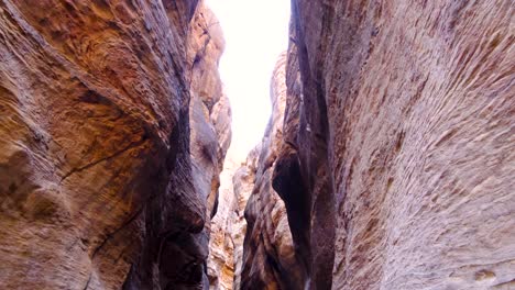 Hiking-through-smooth,-winding,-rocky-and-rugged-canyon-of-Wadi-Ghuweir-in-the-remote-wilderness-of-Jordan