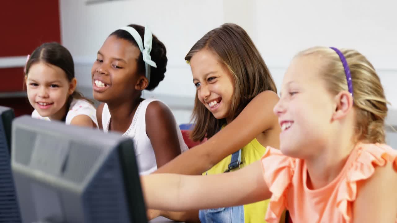 Schoolgirls using computer in classroom
