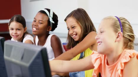 schoolgirls using computer in classroom