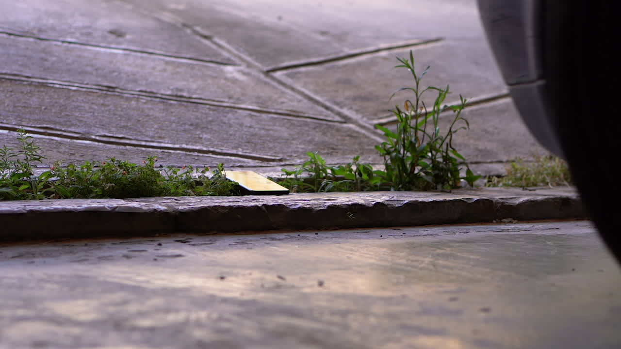 자동차 타이어가 넘어져 스마트폰을 구부리는 모습 - 슈퍼 슬로우 모션 샷을 닫습니다