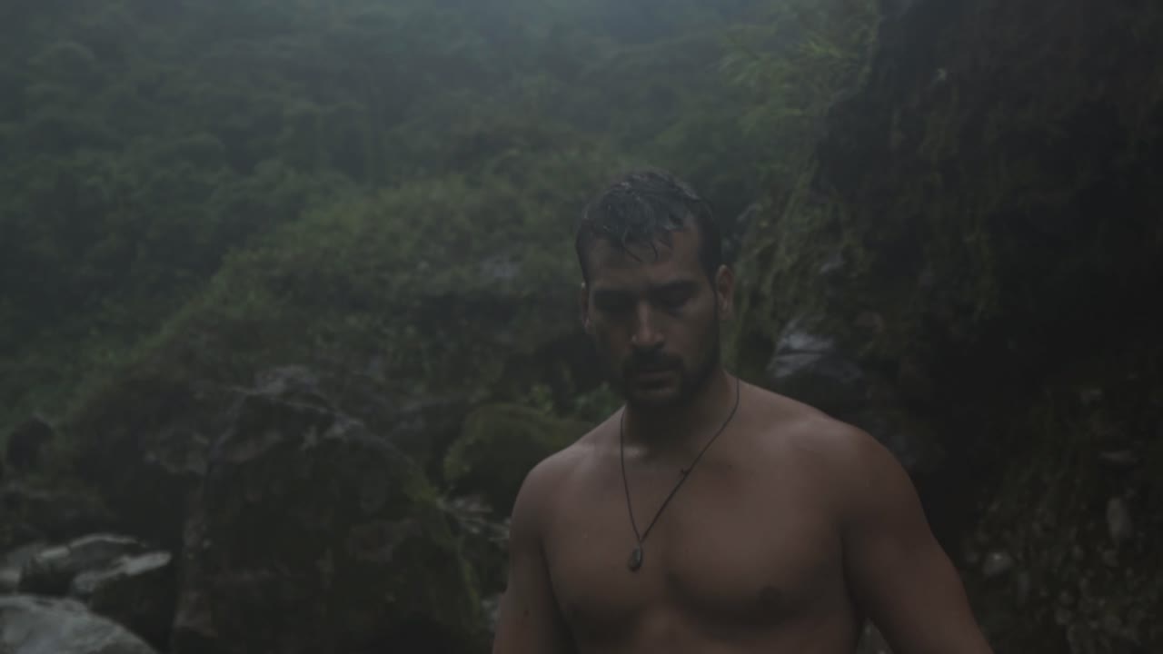 A man with a beard and wet hair is captured in a natural, candid moment walking on the Quebrada Gata trail