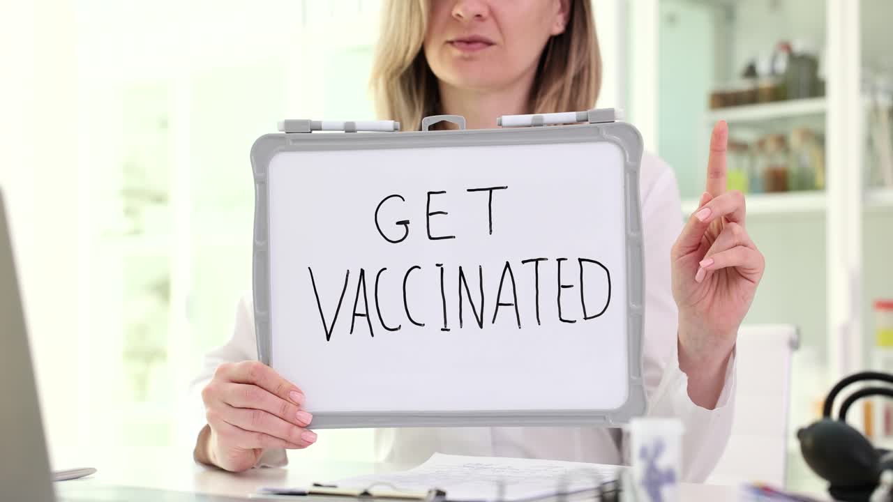 Donna che tiene un cartello con scritto 'Vaccinati'