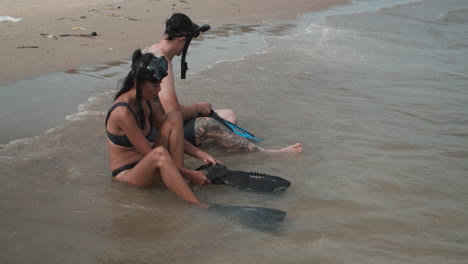 un couple se met des nageoires de plongée