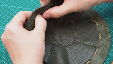 craftsman inserts a cord in the sewn pouch