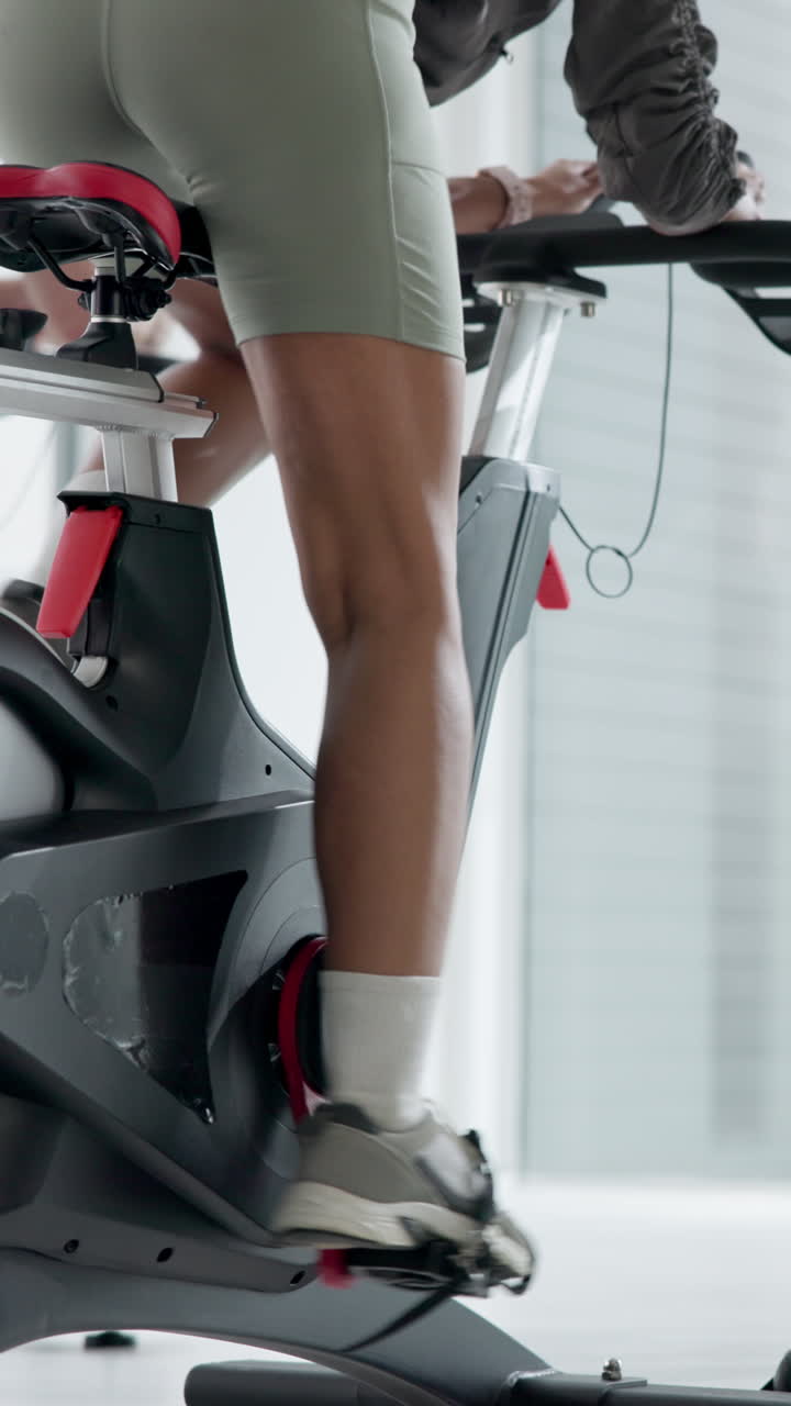 Close-up of Person's Legs Pedaling on a Stationary Bike in a Gym