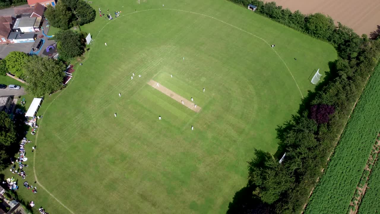 imágenes de drones de 4k de gran altitud de un partido de cricket de un pueblo inglés
