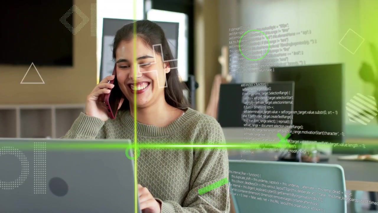 Mujer sentada en un escritorio, sosteniendo un teléfono y escribiendo en una laptop durante una llamada tecnológica, sonriendo y riendo mientras una interfaz HUD verde se desplaza.
