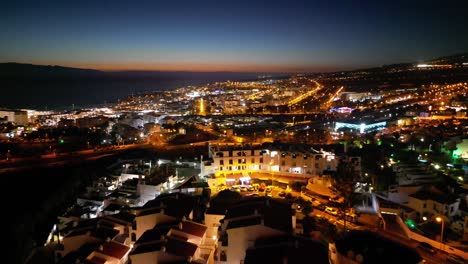 impresionantes vuelos nocturnos hacia atrás sobre áreas residenciales con una carretera lejana