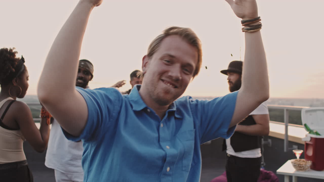 Man Doing Silly Dance Moves at Rooftop Party