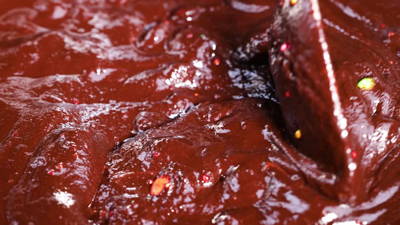 Thick chocolate batter being stirred with spoon