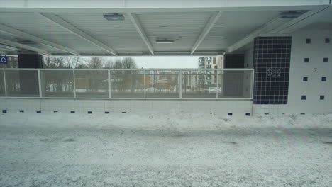 pov: winter commuter train comes to stop at snowy station platform