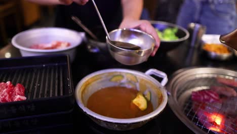 ladling soup into a bowl at a restaurant