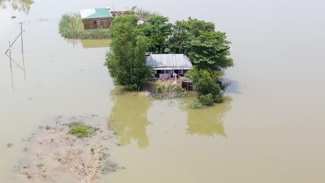 rural village houses submerged by severe flood water in bangladesh. aerial shot