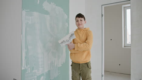 teenager applying plaster to wall