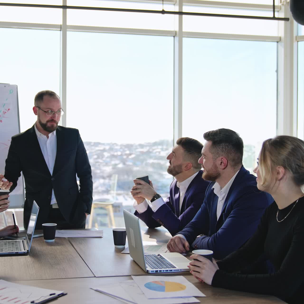 Coworkers sitting at the table and listening to teammate. Colleagues look at their partner and listen to him attentively. Teamwork at conference hall