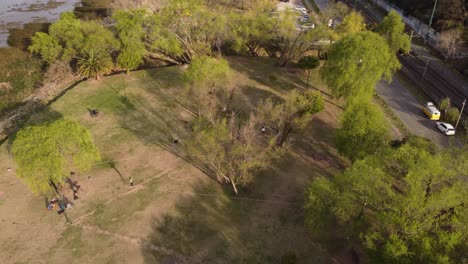 Aerial-top-down-shot-of-Person-balancing-on-slackline-in-park-in-Vicente-Lopez-area-in-Buenos-Aires-at-sunset