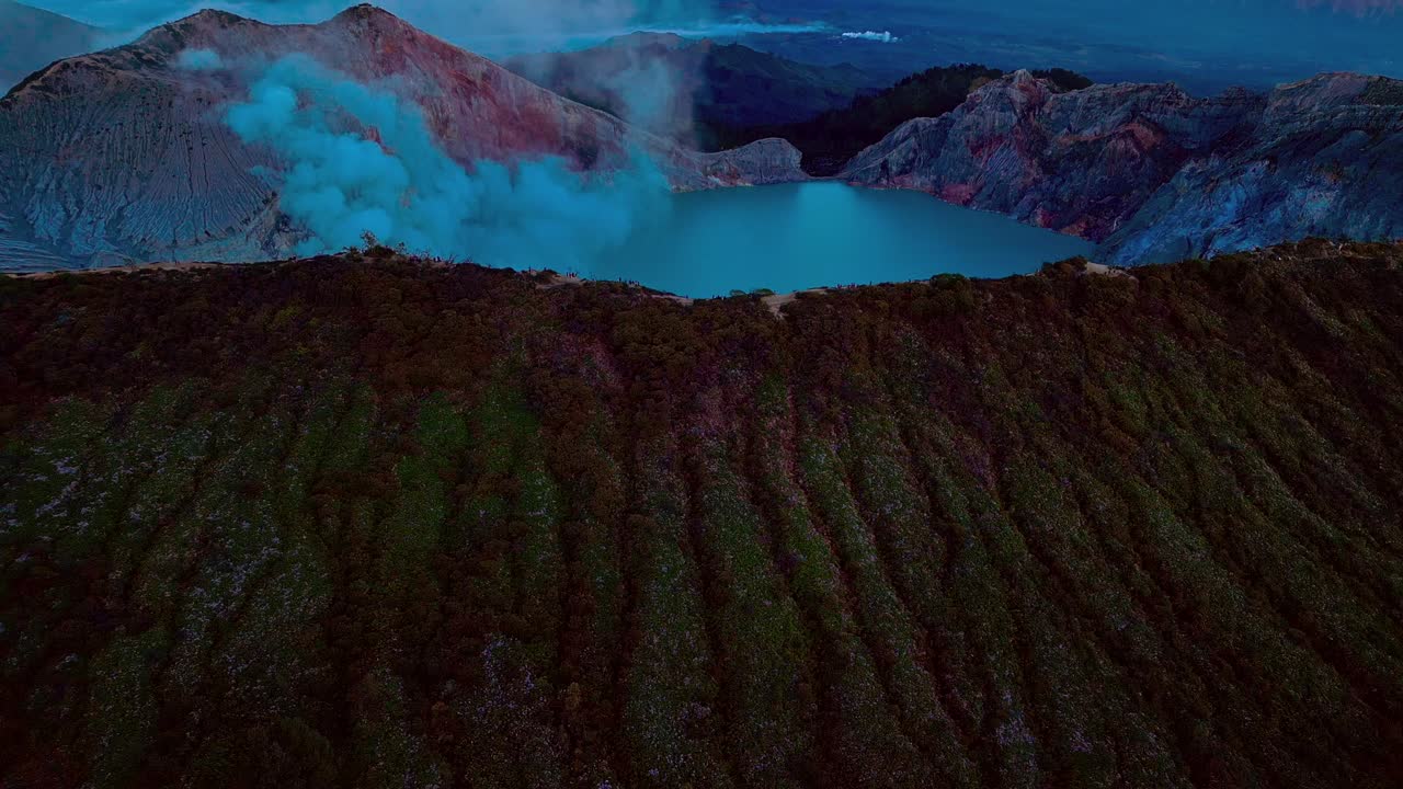 As the sun's first rays kiss the horizon, the volcano's silhouette awakens, revealing the majestic Ijen Crater