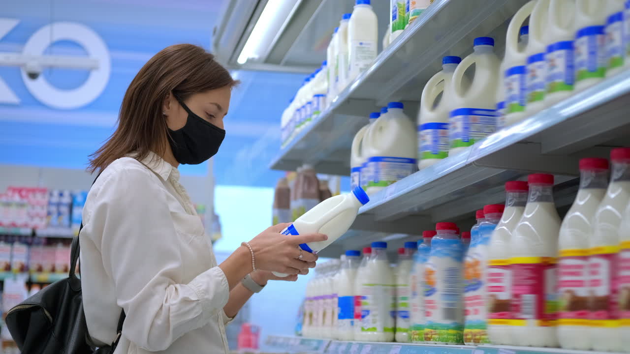 슈퍼마켓 에서 우유 를 구입 하는 여자