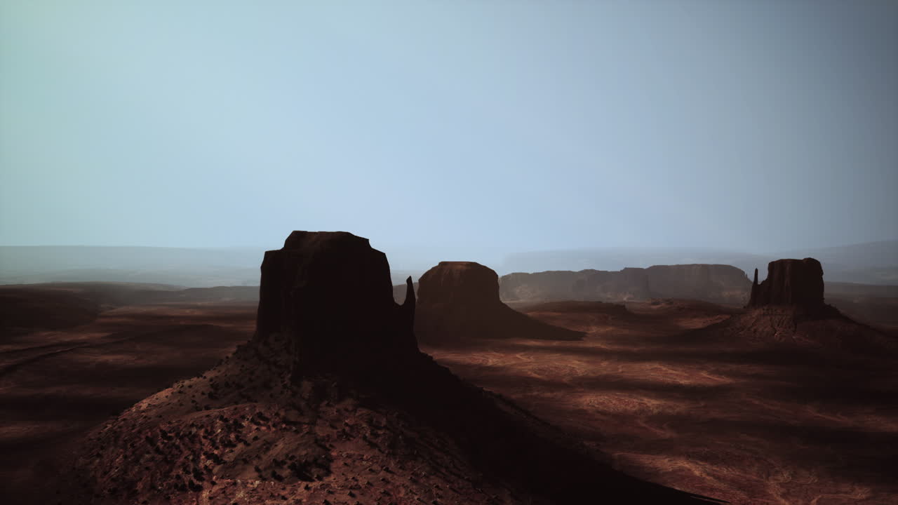 Monument valley landscape at dusk with silhouetted buttes