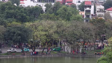 people and vehicles around hanoi lakefront