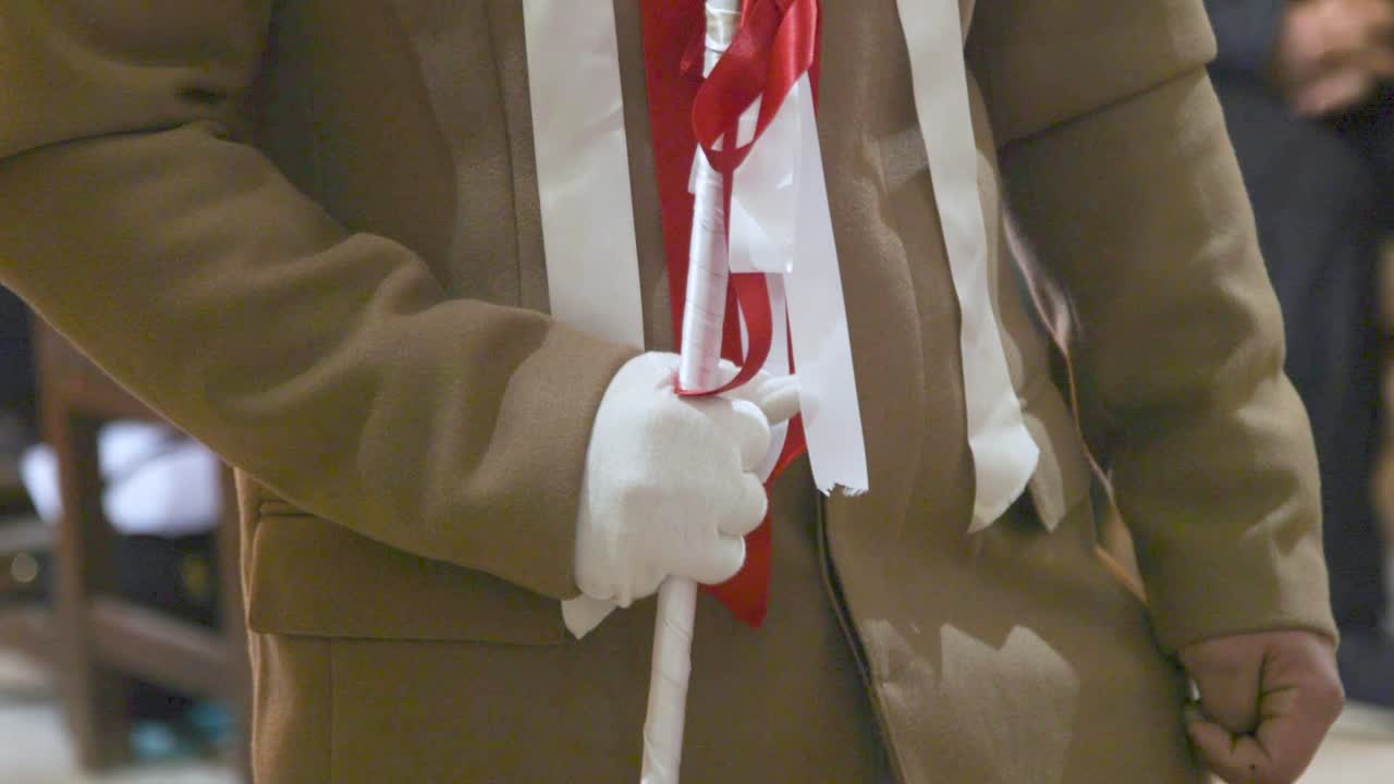 Man with white glove holding stick, truncheon during church ceremony