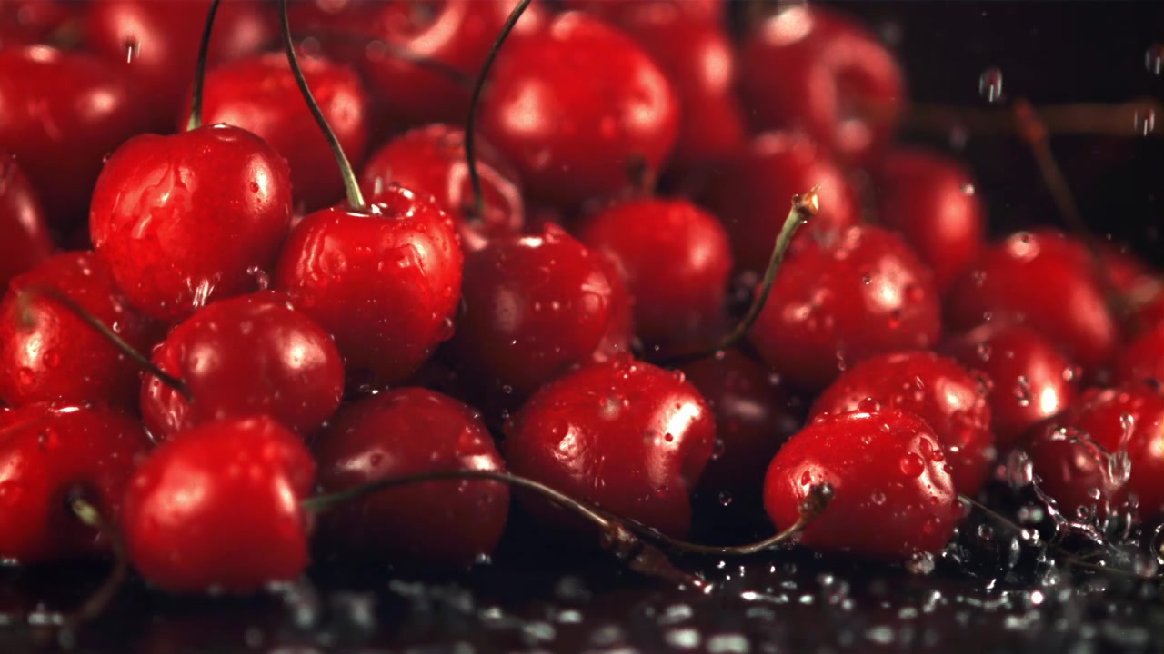 Acqua che schizza su ciliegie rosse fresche al rallentatore