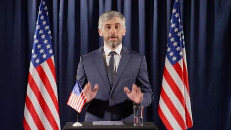 politician giving speech by rostrum at press conference