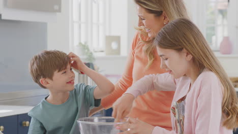 Madre-Con-Dos-Hijos-En-La-Cocina-De-Casa-Divirtiéndose-Horneando-Pasteles-Juntos