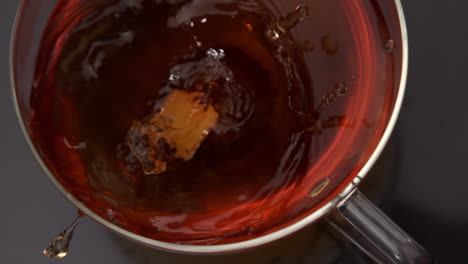 sugar cube falling into cup of tea