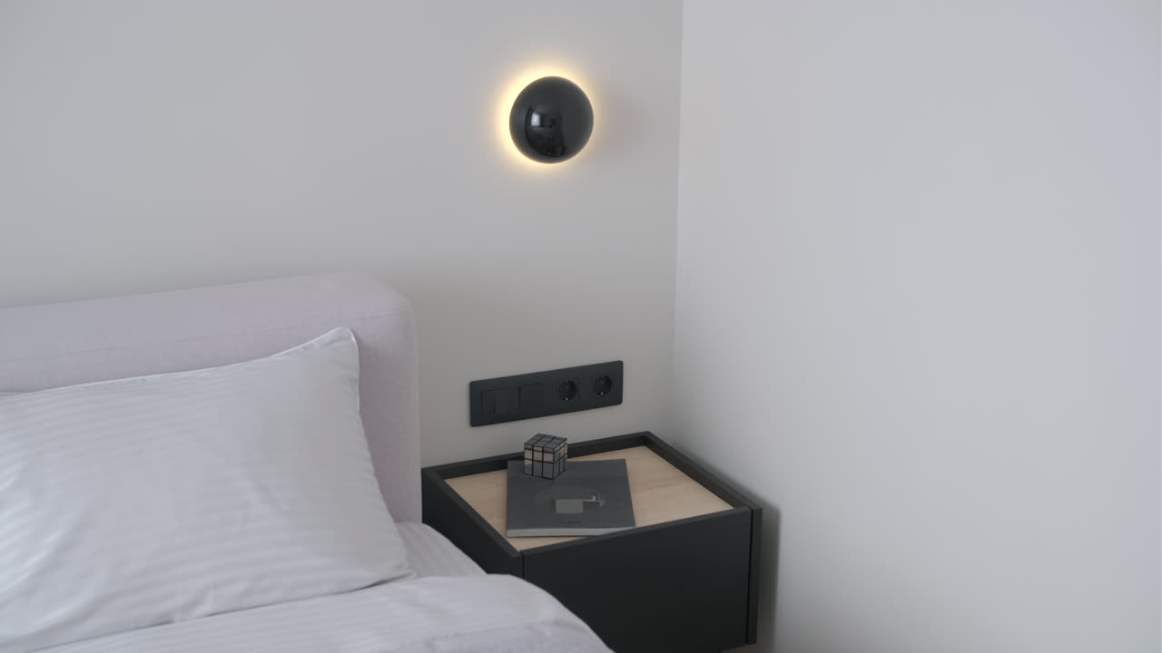 Moderne soveromshjørne med seng, nattbord og vegglampe