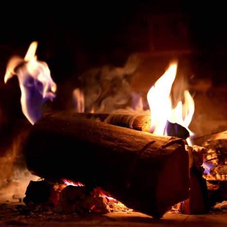 wooden logs in fire on brick fireplace background. wood burning in fire flame. cozy warm fireplace in a country house. close-up