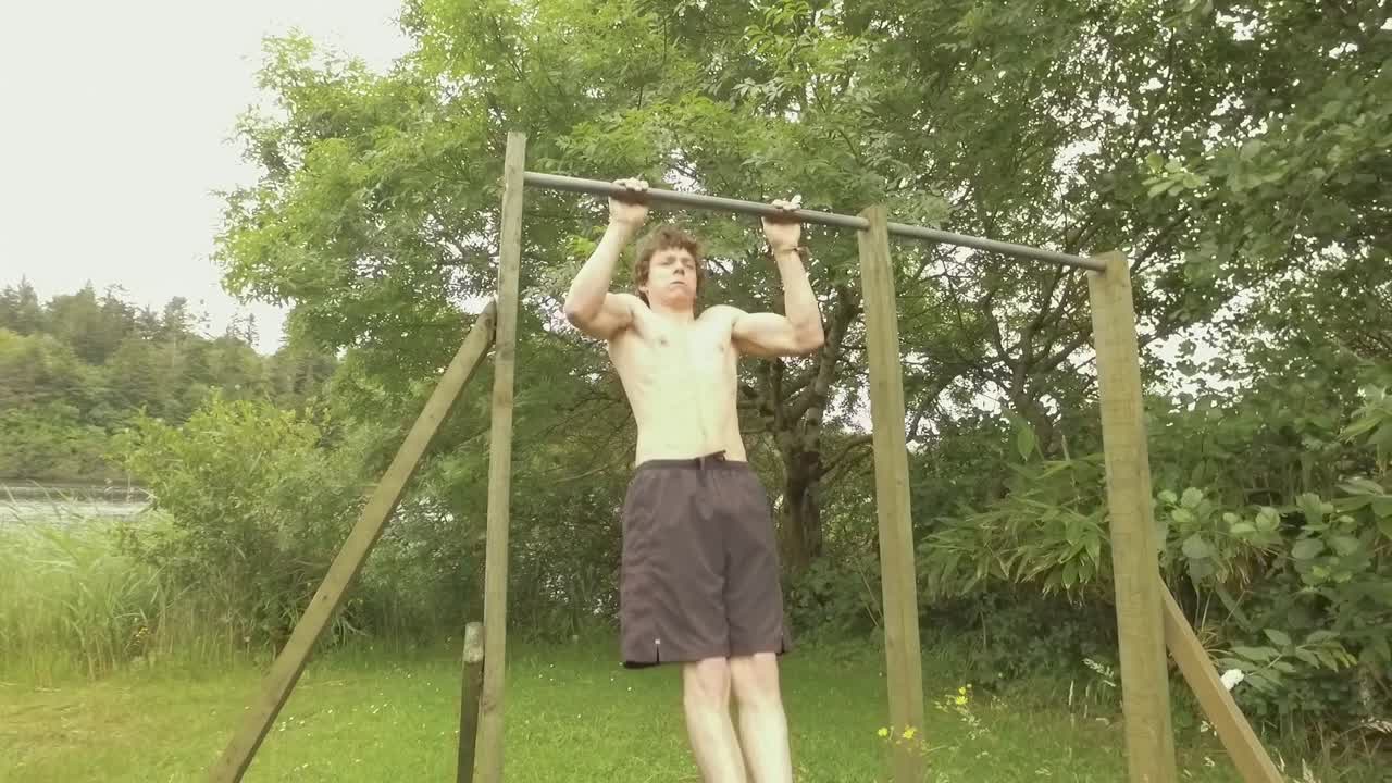 홈 체육관 슬로우 모션에서 풀업을 하는 의욕적인 운동 청년