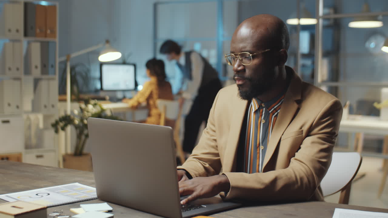 African American Businessman Working on Laptop Late in Office