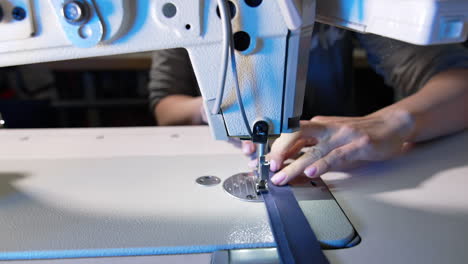 women hands working with modern sewing machine. textile factory clothes.