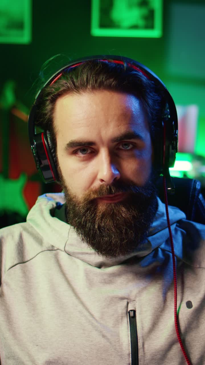 Video verticale di un gamer in una casa illuminata al neon, dispiaciuto per aver perso contro un avversario in una competizione di eSport online