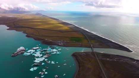 un vuelo de avión no tripulado sobre una laguna glacial en islandia con icebergs flotantes
