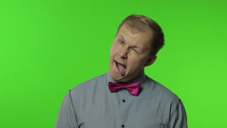 positive man having fun in front of camera, showing tongue out, childish mood, positive emotions