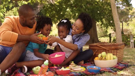 cute family is eating in a park