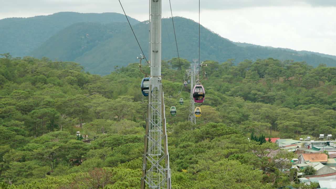 Passenger's POV Dalat Cable Car Gondola Ride Moving Over Stunning Mountain Range Valley and Village Surrounded With Dense Green Forests, Vietnam