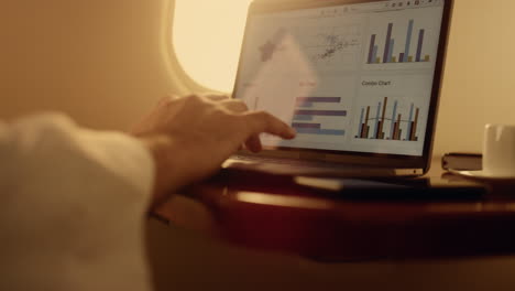 hands working digital computer closeup. manager checking company graphs on plane